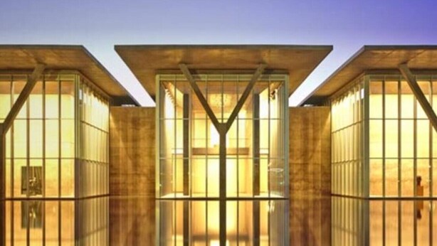 A modern building with a central glass facade and metal beams. - Relaxing Extended stays, walk Downtown! (Fort Worth)