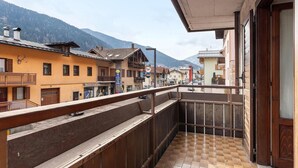 A balcony with a view of a mountain, a wooden railing, and a tiled floor. - Room 'Bed and Breakfast Pellizzano' (Pellizzano)