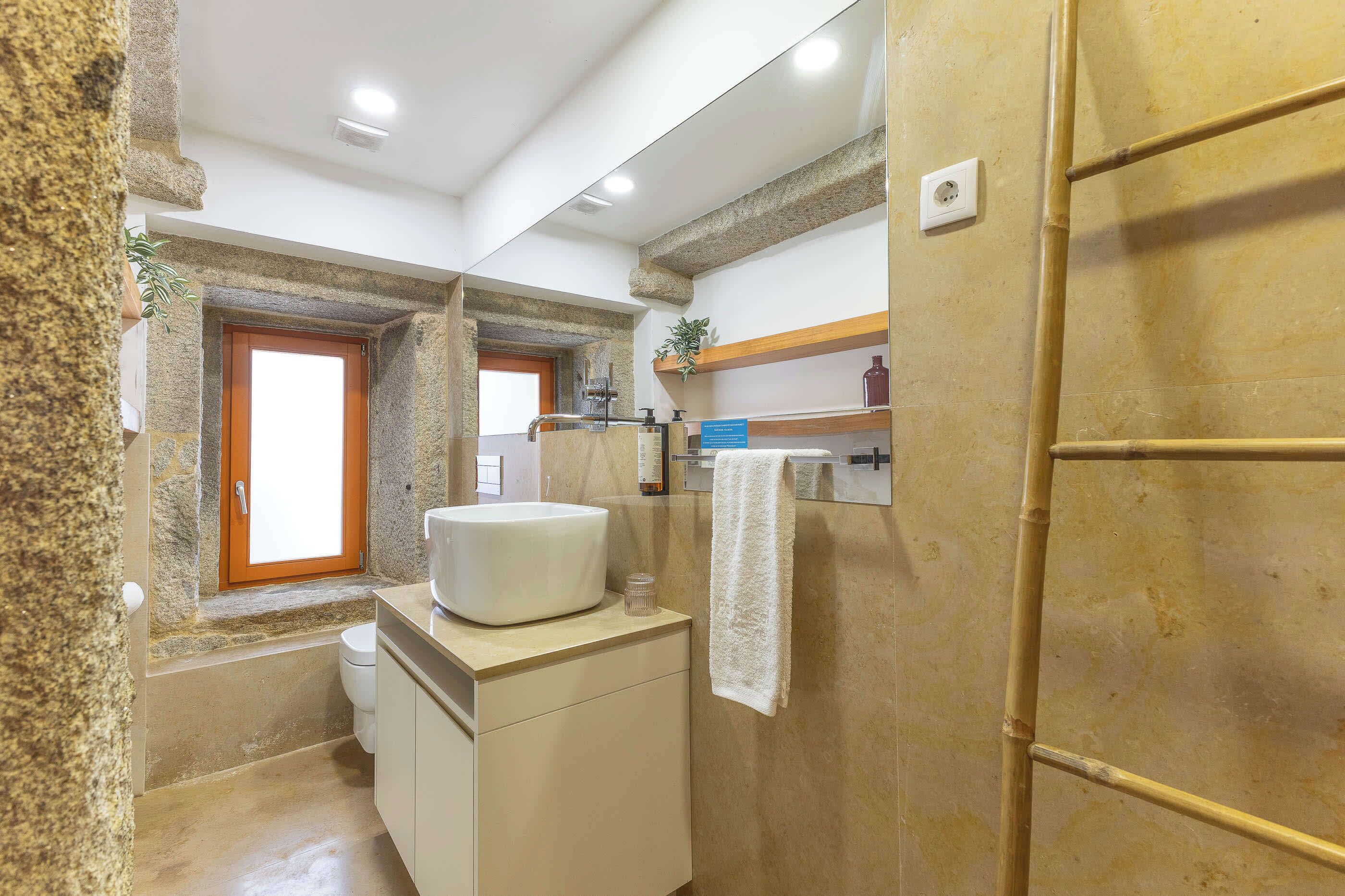 A bathroom with a bathtub, a sink, a towel rack, and a shower area.