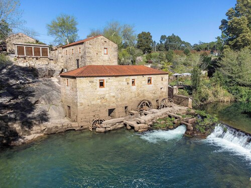 Jahrhundertealte Wassermühle am Flussufer by Portugal Active