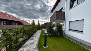 A residential area with modern houses, a paved pathway, and a well-maintained lawn. - Holiday apartment Wiesenweg (Seeg)