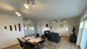 Ett rymligt vardagsrum med ett matbord, en soffa och ett TV-bord.