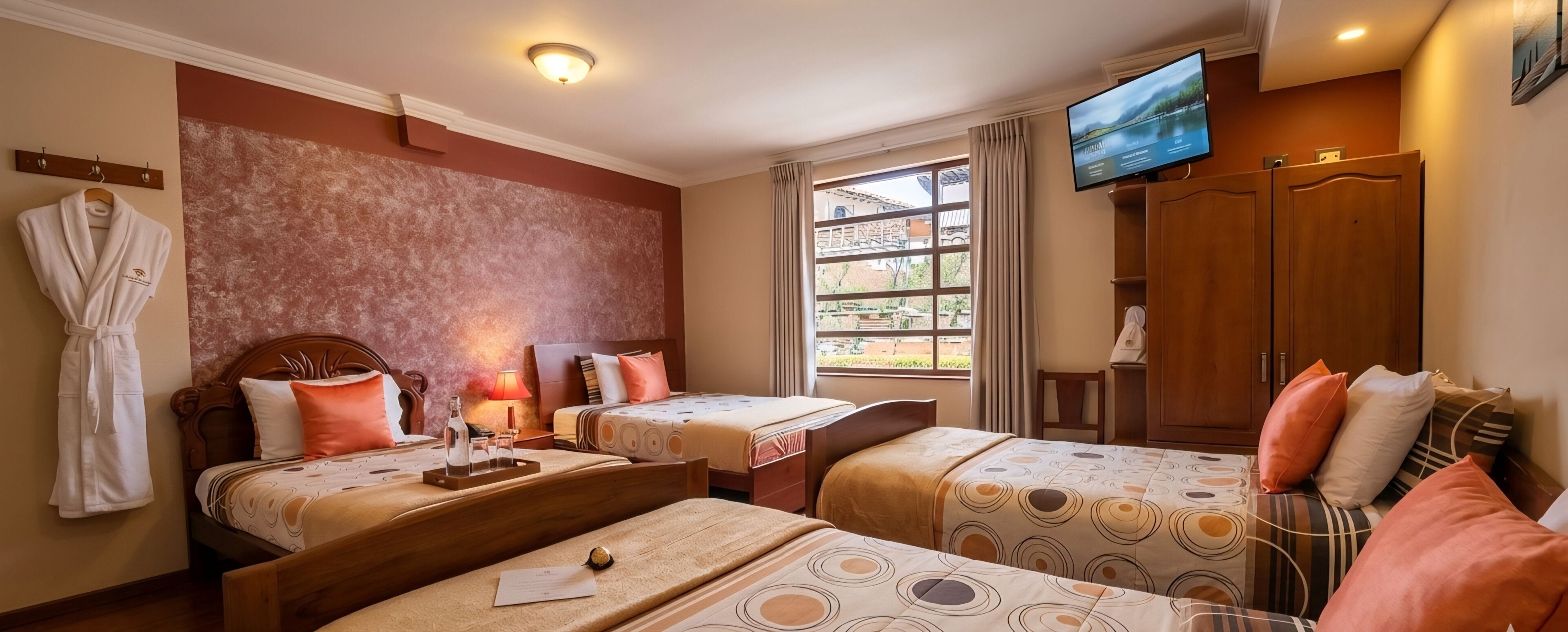 Une chambre d’hôtel avec deux lits, une télévision, une fenêtre donnant sur un paysage agréable et une armoire en bois.