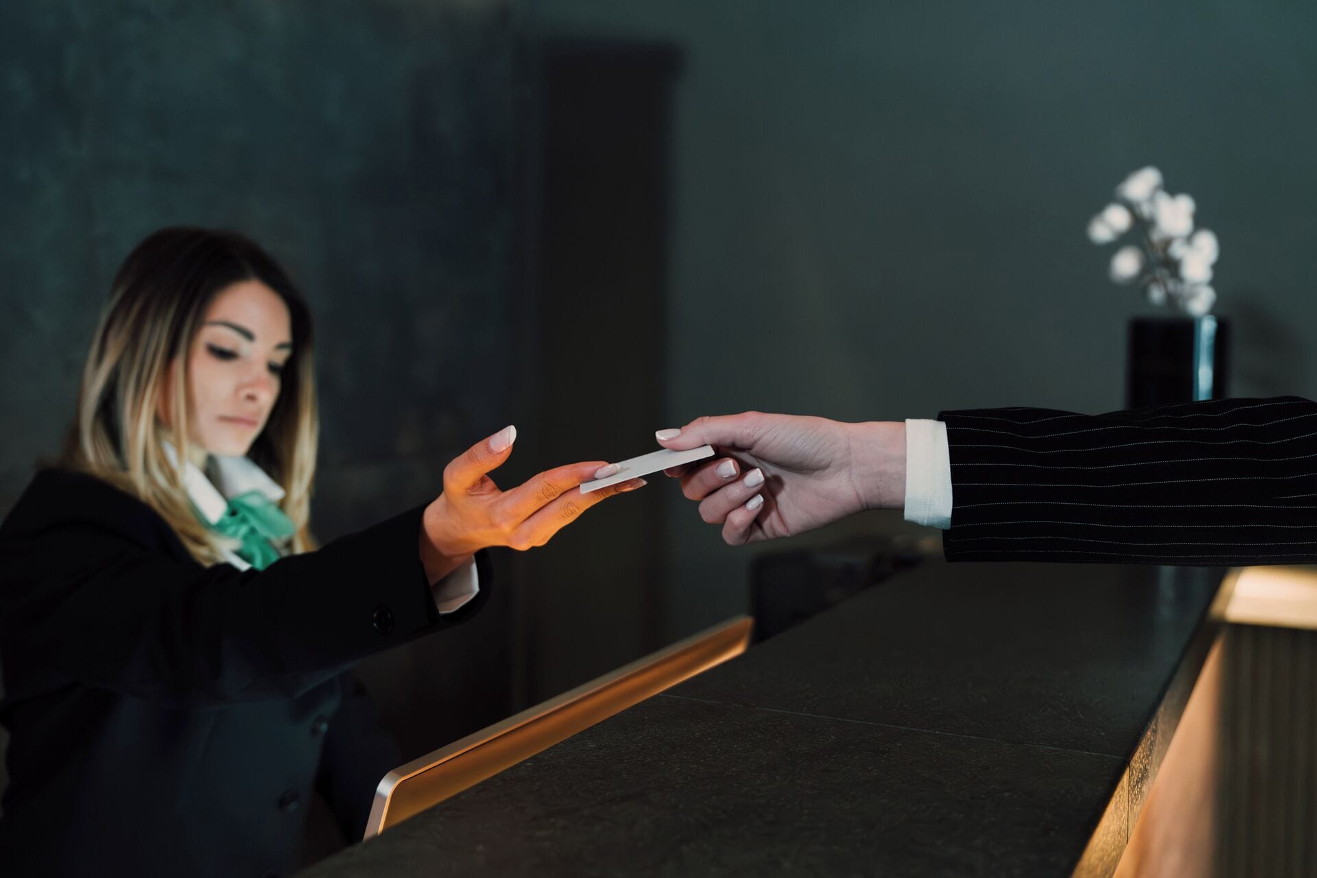 Eine Person übergibt am Empfang eine Karte an eine andere Person.