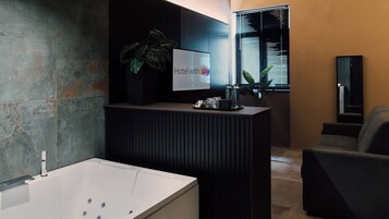 Un bagno moderno con una vasca da bagno ampia, un lavabo con una pianta e un cartello che dice 'Hotel con sky'.
