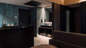 A modern bathroom with a dark wood vanity, a mirror, and a towel rack. - Hotel Palazzo Pepe (Naples)