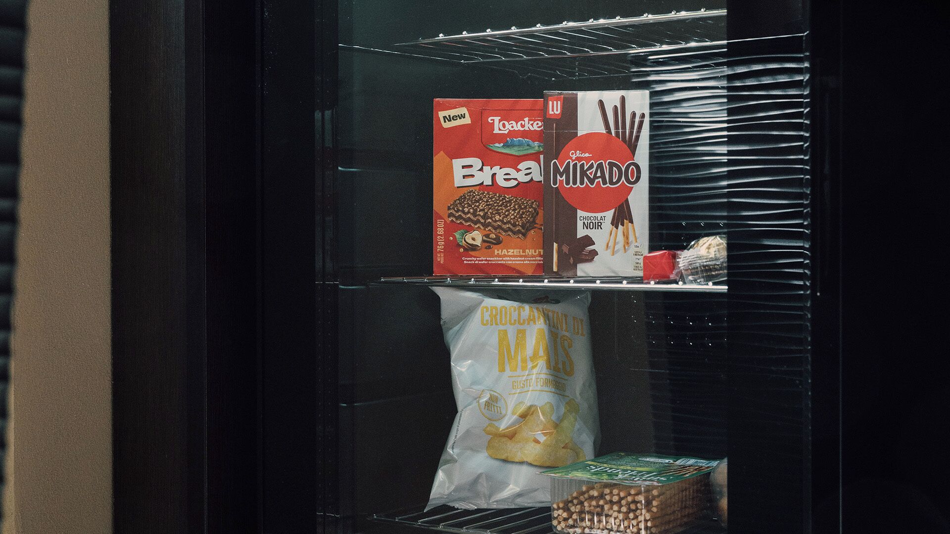 Una macchina distributrice automatica con una barretta al cioccolato Toasterie Break MIKADO e patatine di mais croccanti.