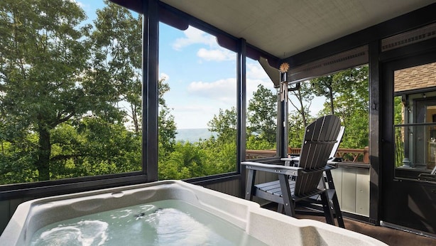 Un bain à remous sur un balcon avec vue sur les arbres et l’océan.