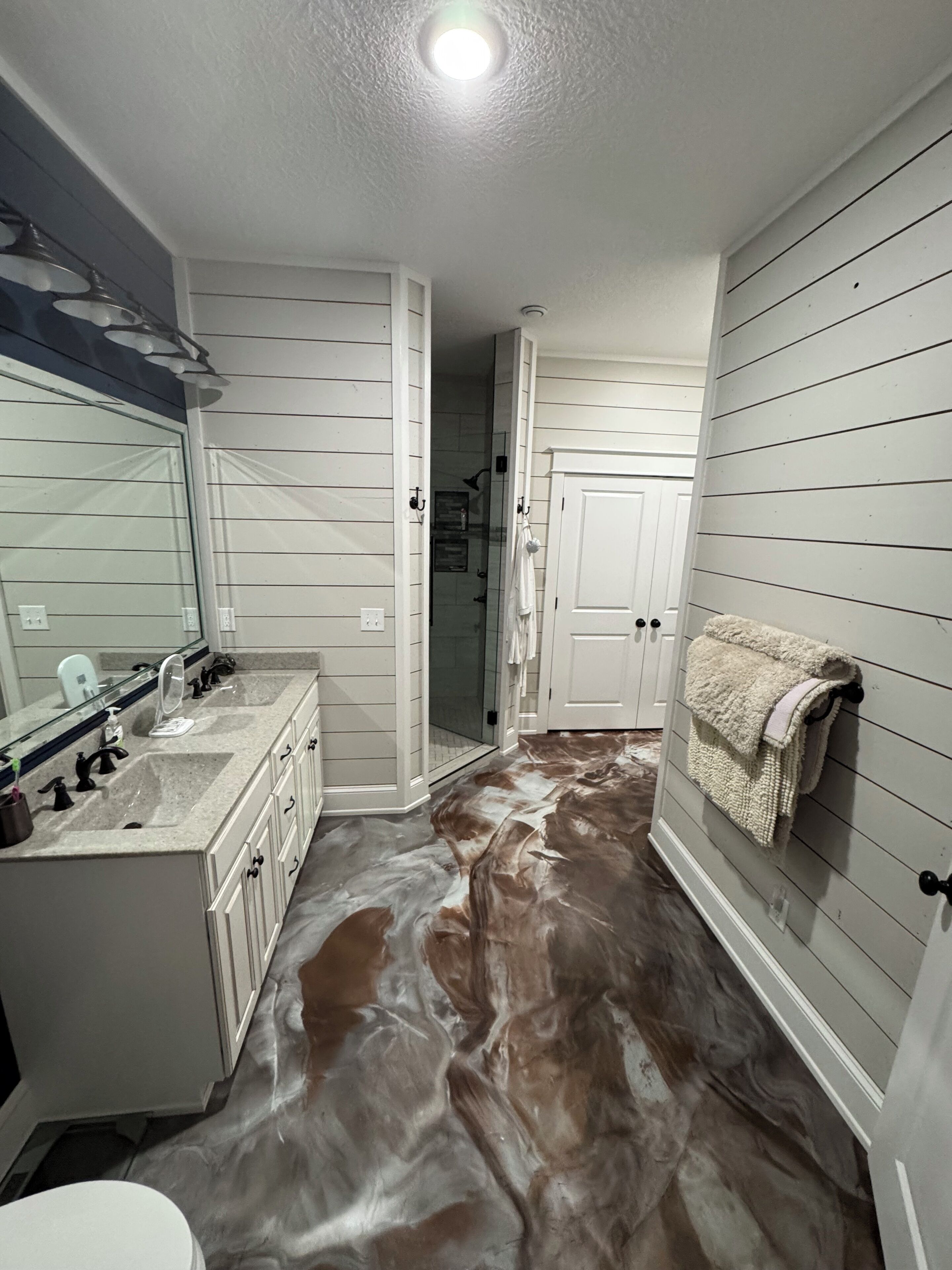 Een badkamer met een douche, een wastafel en een spiegel.