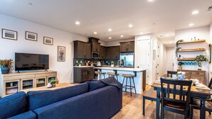 Una cocina moderna con comedor, sofá y televisor.