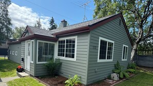 A single-story house with a front porch, a chimney, and a number '112' on the side. - Downtown home w/patio in historic Pilot's Row (Anchorage)