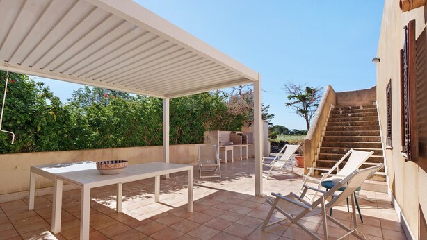 An outdoor patio with a table, chairs, and a bowl. - Villa 'Diego' with Sea View, Wi-Fi and Air Conditioning (Favignana)