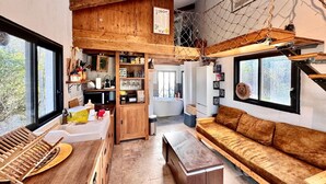 Ein gemütliches Interieur mit einem Schlafzimmerpodest, einem Essbereich und einer Couch.