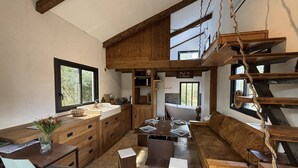 Eine geräumige Küche mit Holzschränken, ein Essbereich mit Tisch und Stühlen sowie ein großes Fenster für natürliches Licht.