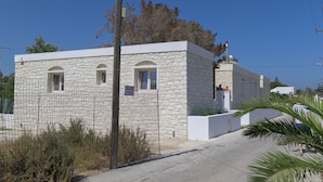 Un bâtiment en pierre doté de fenêtres en arc et d’une façade blanche.