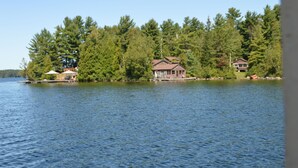 A lakeside property with a house surrounded by dense trees. - Tamar Vacations (Temagami)