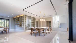 A spacious dining area with a large table and chairs, a built-in bookshelf, and a modern ceiling design. - Mansão de Luxo a 35 minutos de SP (Araçariguama)