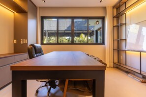 A conference room with a long table, chairs, a window with a view, and a bookshelf. - Mansão de Luxo a 35 minutos de SP (Araçariguama)