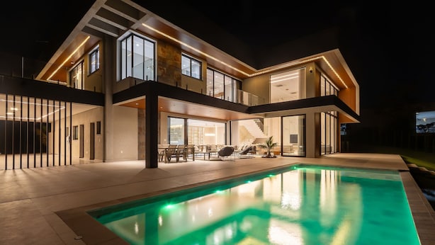 A modern multi-story house with a swimming pool, large windows, and outdoor seating. - Mansão de Luxo a 35 minutos de SP (Araçariguama)