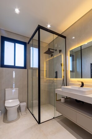 A modern bathroom with a glass-enclosed shower, a white toilet, and a large mirror above a white sink. - Mansão de Luxo a 35 minutos de SP (Araçariguama)