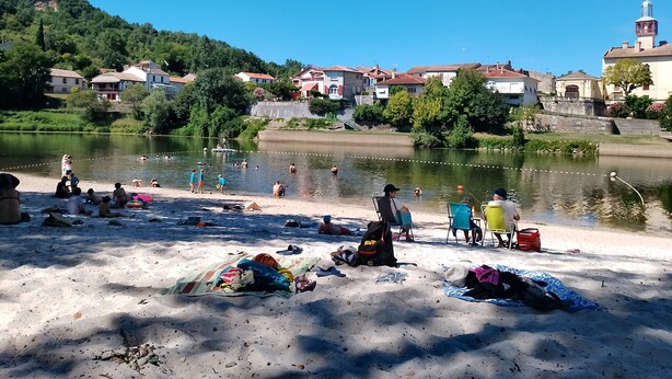 A riverside beach with people swimming and sunbathing, surrounded by houses and a hill. - Welcome to your future cocoon! 54 m² house entirely renovated (Castelmoron-sur-Lot)