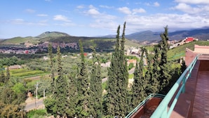 A balcony with a view of a town, trees, and distant mountains. - Le joyau de l'ourika (Ourika)