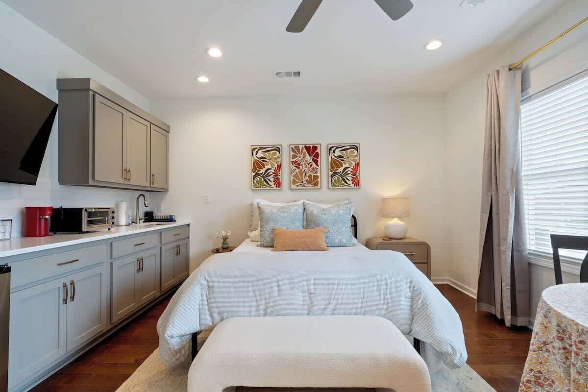 A bedroom with a bed, bedside table, and a window with curtains.