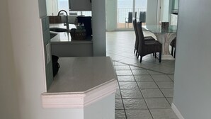 Amplia sala de estar con cocina, comedor y vista al océano.