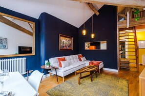 Ein modernes Wohnzimmer mit einer Couch, einem Couchtisch und einem Essbereich mit Tisch und Stühlen.