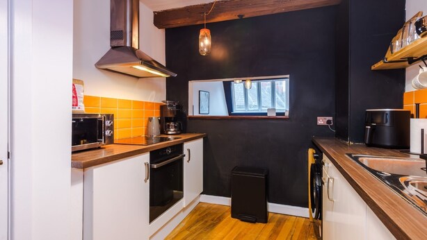 Eine kompakte Küche mit eingebautem Backofen, einer Kaffeemaschine und einem Toaster.