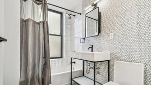 Un baño con bañera, inodoro y lavamanos.