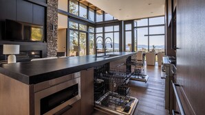 A modern kitchen with a large island, built-in appliances, and a view of the outdoors. - The Edge - Modern Retreat with Panoramic Views (Sandpoint)