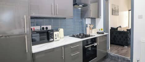 Una cocina moderna con gabinetes grises, microondas, tostadora y estufa.