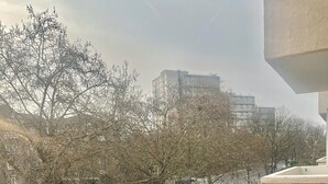 A balcony with a round table and two chairs, overlooking a street with trees and buildings. - Bright 2-Bed Apt with Balcony in Zone 2 London, 3min walk from MaidaVale tubestn (London)