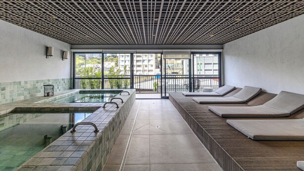 A spa area with a pool, lounge chairs, and a view of the outside. - Update  (São Paulo)