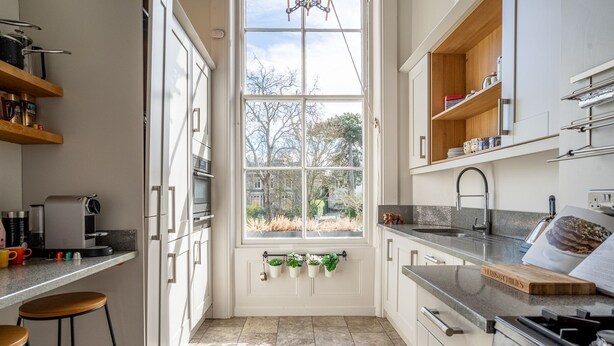 A modern kitchen with a large window, built-in shelves, and a gas stove. - The Classic on the Mount -  a premium stay that sleeps 4 guests  in 2 bedrooms (York)