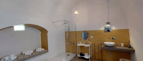 Une salle de bain équipée d’une douche, d’un lavabo, d’un miroir et de toilettes.