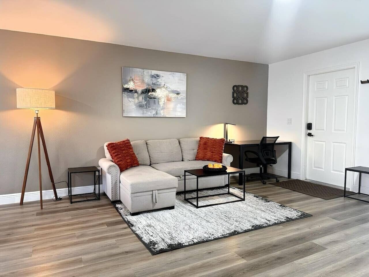 Ein modernes Wohnzimmer mit Sofa, Couchtisch und Lampe.