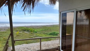 Un balcon avec vue sur la plage et l’océan.