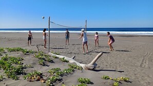 Un match de volleyball de plage avec des joueurs et un filet sur une plage de sable.