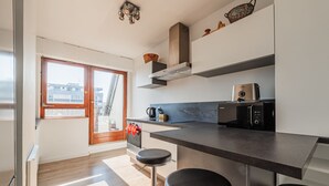 Una cocina moderna con un ventanal grande, horno empotrado, microondas y cafetera.