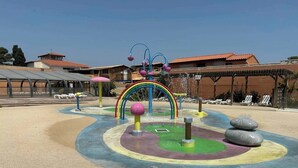 A water play area with a rainbow arch, colorful play structures, and a sandy ground. - Mobile home near the sea, Camping 4* Mar Estang (Canet-en-Roussillon)