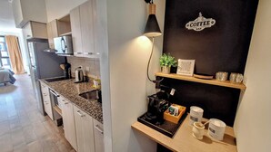 Una cucina moderna con piani in granito, un angolo caffetteria con un cartello e un codice QR per i social media.