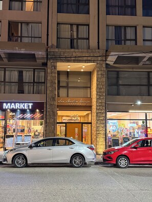 Een gebouw met een etalage waarop 'San Martin Design' staat en een bord met 'Markt'. Er staan twee auto's ervoor geparkeerd.