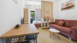 Una sala moderna con una mesa de comedor de madera, un sofá y una mesa de centro blanca.