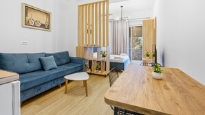 Una sala moderna con sofá, mesa de comedor y un separador de madera.