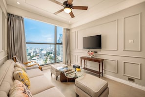 A modern living room with a sofa, coffee table, and TV. - Luxury Apartment Seaside (Da Nang)