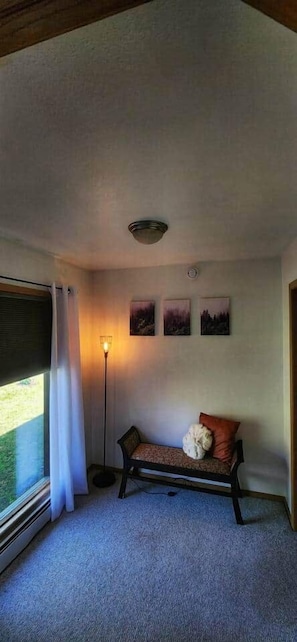 A room with a bench, a floor lamp, and three framed pictures on the wall. - Spacious house near Soldotna, AK (Ridgeway)