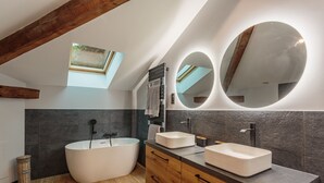 A modern bathroom with a freestanding bathtub, two sinks, a vanity with drawers, a large mirror, and a skylight. - Domaine Le Pehau 4 - Avec jardin et terrasse (Osserain-Rivareyte)