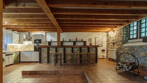 Une cuisine rustique avec des poutres en bois, un mur en pierre et un coin bar.